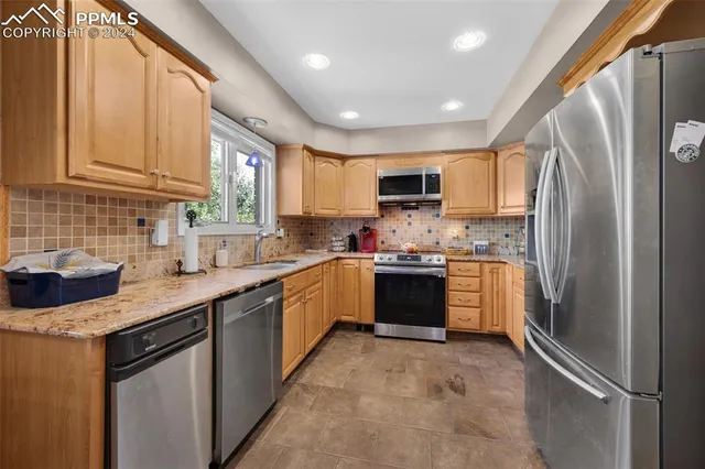 a kitchen with stainless steel appliances granite countertop a refrigerator sink and microwave