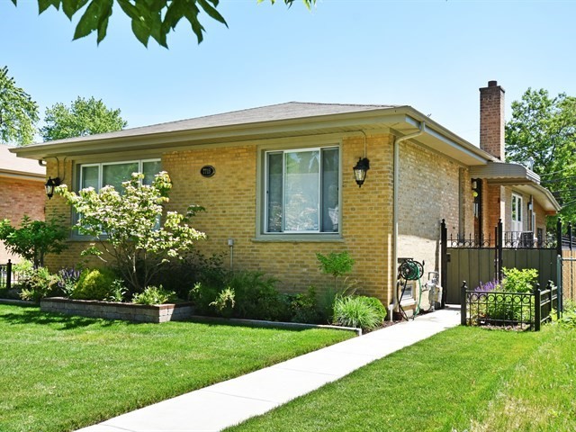 7715 East Prairie Road Skokie, IL 60076 - Photo 2 of 26 a front view of a house with a garden