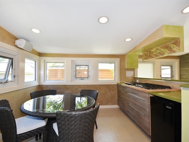7715 East Prairie Road Skokie, IL 60076 - Photo 14 of 26 a kitchen with a stove a sink a dining table and chairs