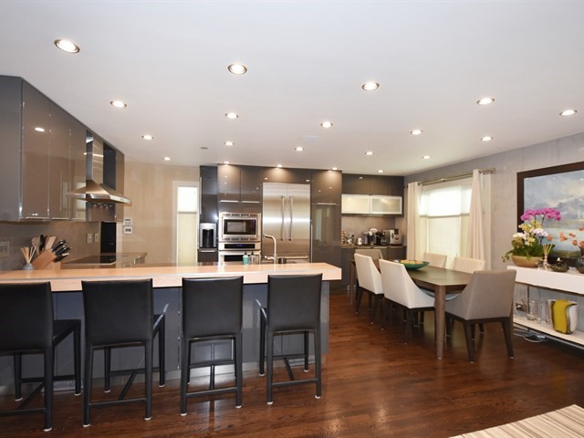 7715 East Prairie Road Skokie, IL 60076 - Photo 7 of 26 a dining room with stainless steel appliances kitchen island granite countertop a dining table chairs and kitchen view