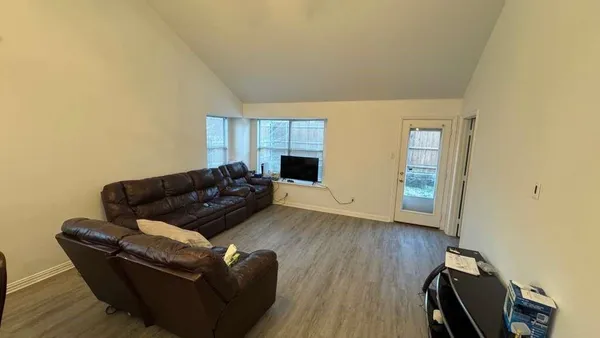a living room with furniture and a wooden floor