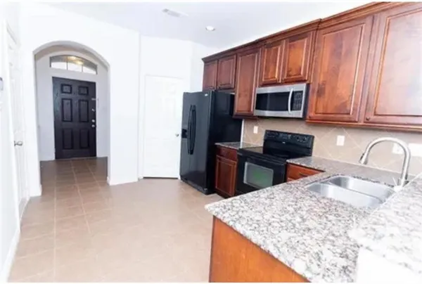 a kitchen with stainless steel appliances granite countertop a sink refrigerator and microwave