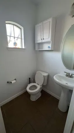 a bathroom with a toilet a sink and mirror