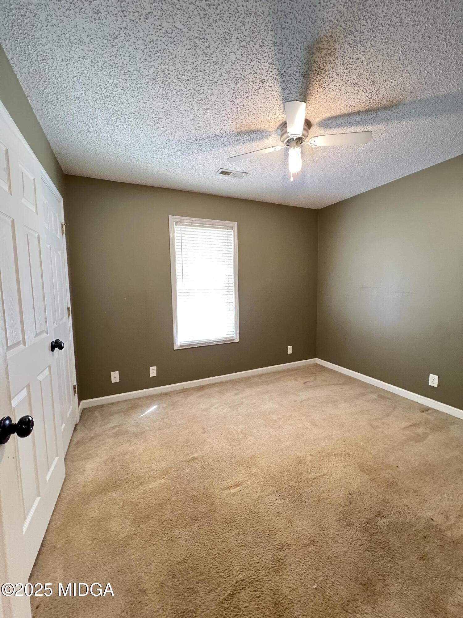 231 Red Berry Road Jackson, GA 30233 - Photo 16 of 23 an empty room with windows and fan