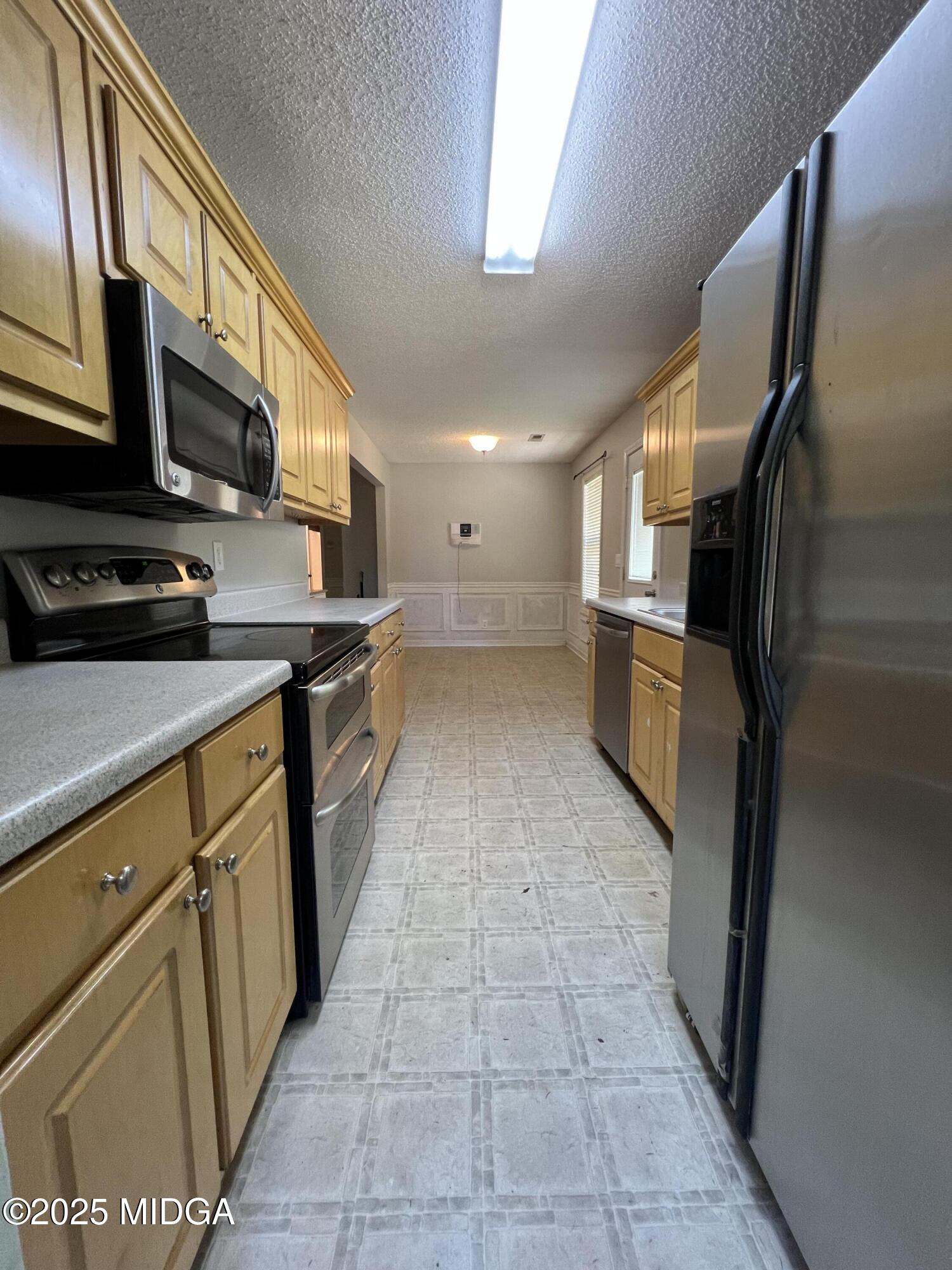 231 Red Berry Road Jackson, GA 30233 - Photo 8 of 23 a kitchen with stainless steel appliances granite countertop a refrigerator a stove top oven and a sink