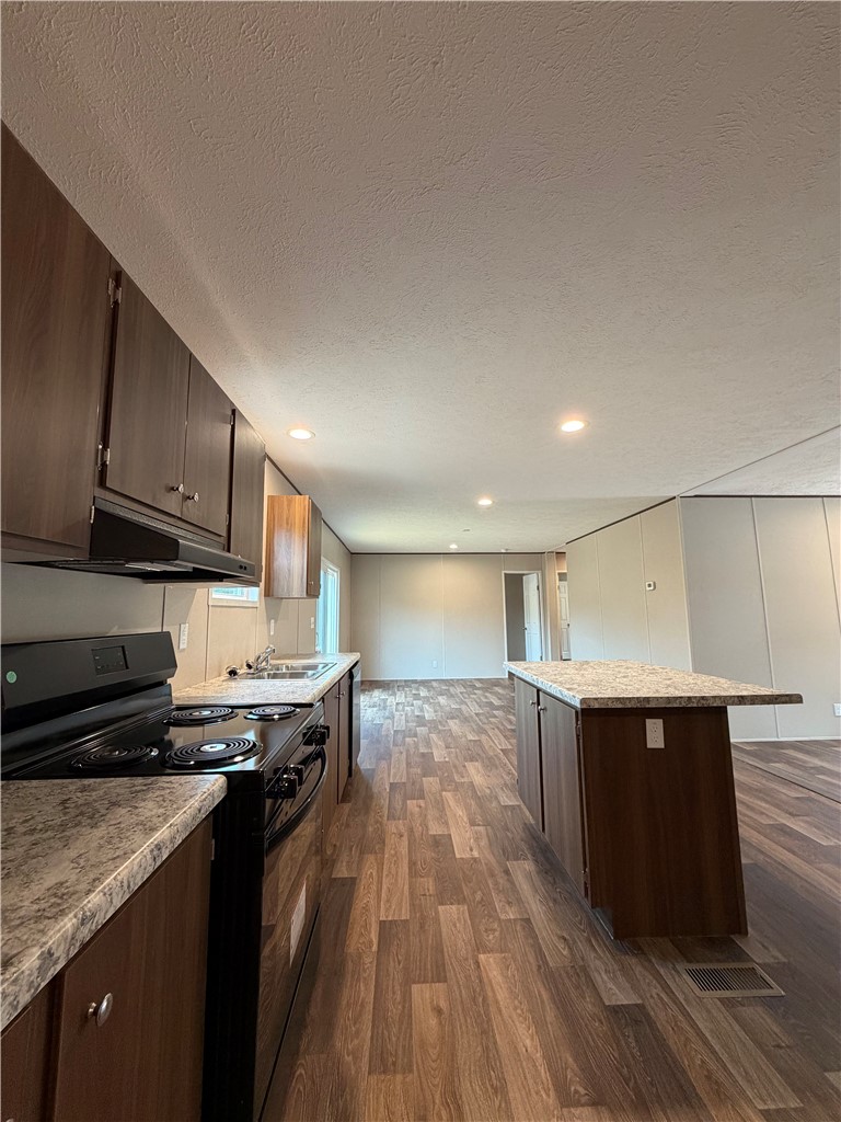 1411 Slaton Road Townville, SC 29689 - Photo 7 of 17 Rich wood-toned cabinetry and a central island ground this open-concept kitchen space.