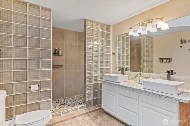 a bathroom with a sink a toilet and shower