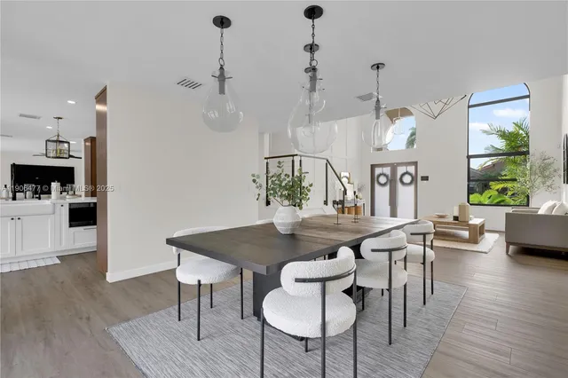 a kitchen with a dining table chairs sink and stove