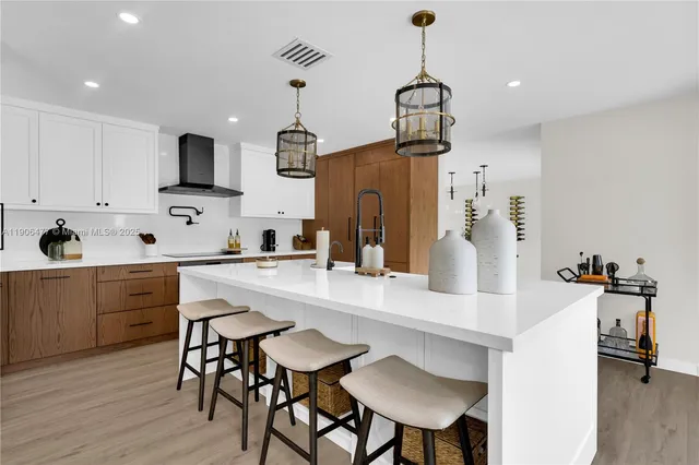 a kitchen with stainless steel appliances a dining table chairs sink and wooden floor
