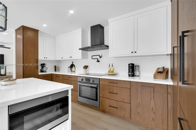 a kitchen with stainless steel appliances kitchen island a sink a stove and cabinets