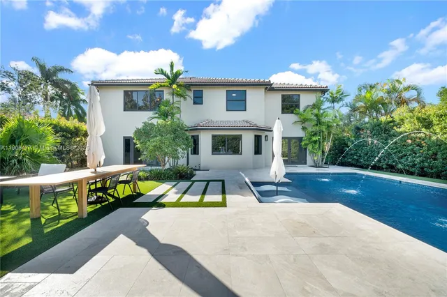 a view of a house with pool and sitting area