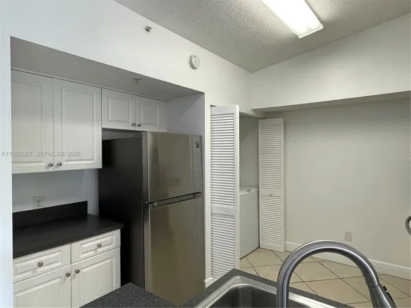 a kitchen with a refrigerator a stove and cabinets