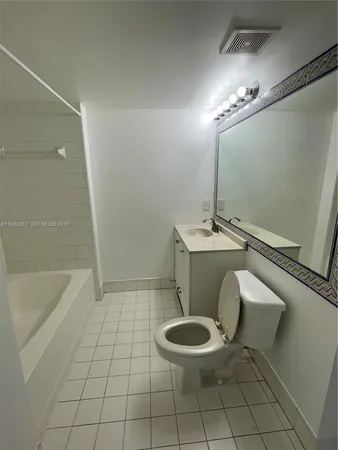 a bathroom with a sink a toilet a mirror and bathtub