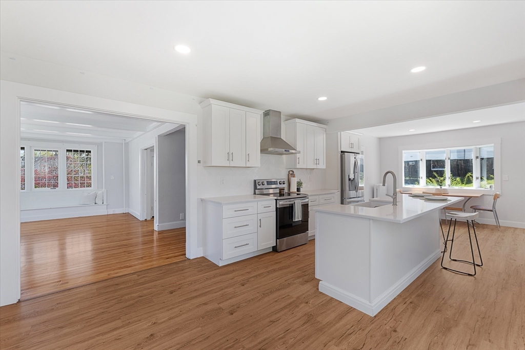 4 Chamberlain Parkway Worcester, MA 01602 - Photo 13 of 42 a kitchen with stainless steel appliances granite countertop a stove top oven a sink dishwasher and a refrigerator with wooden floors