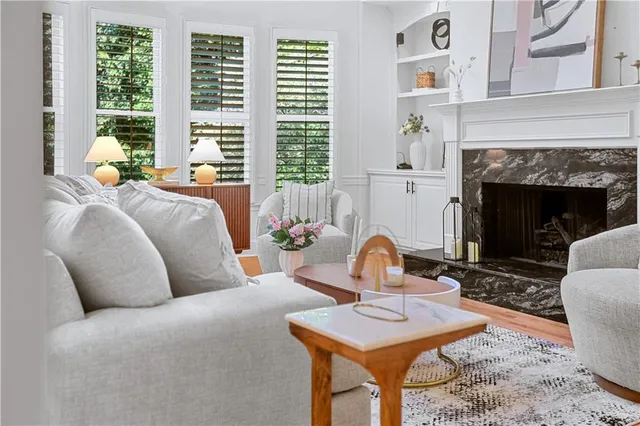 a living room with couches and a dining table with wooden floor