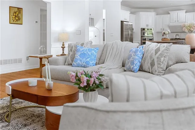a living room with furniture appliances and wooden floor