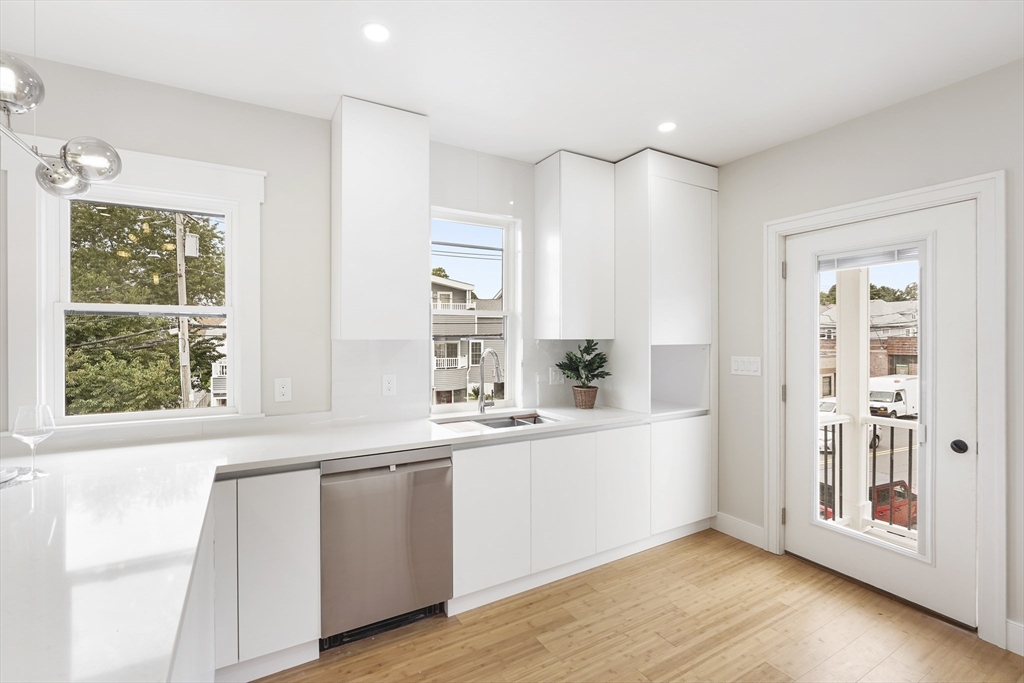 86 Cypress Street, Unit 86 Watertown, MA 02472 - Photo 17 of 38 a view of a kitchen with a sink dishwasher and wooden floor