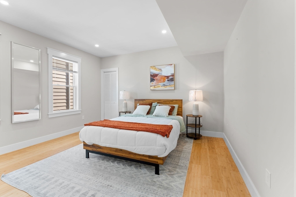 86 Cypress Street, Unit 86 Watertown, MA 02472 - Photo 18 of 38 a bedroom with a bed and wooden floor