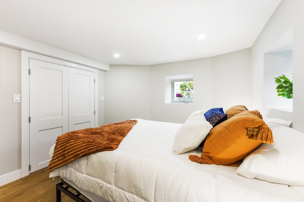 86 Cypress Street, Unit 86 Watertown, MA 02472 - Photo 34 of 38 a bedroom with a bed and painting on the wall