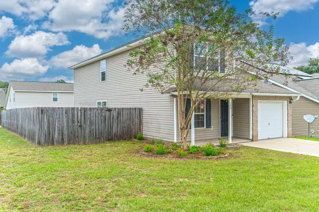a front view of a house with a yard and fence
