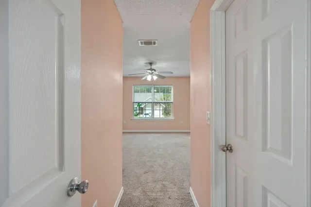 an empty room with a window and a ceiling fan