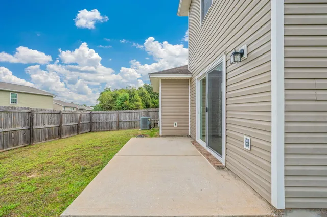 a view of a backyard with table and chairs and potted plants