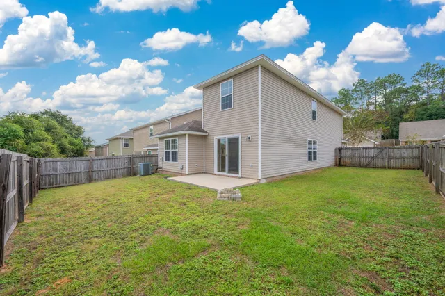 a view of a yard in front of a house with wooden fence