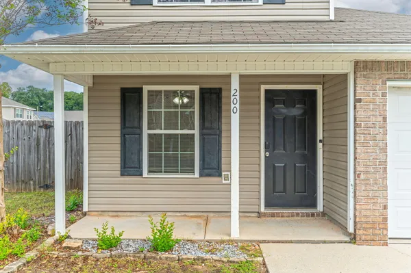 a front view of a house with a window and a chair