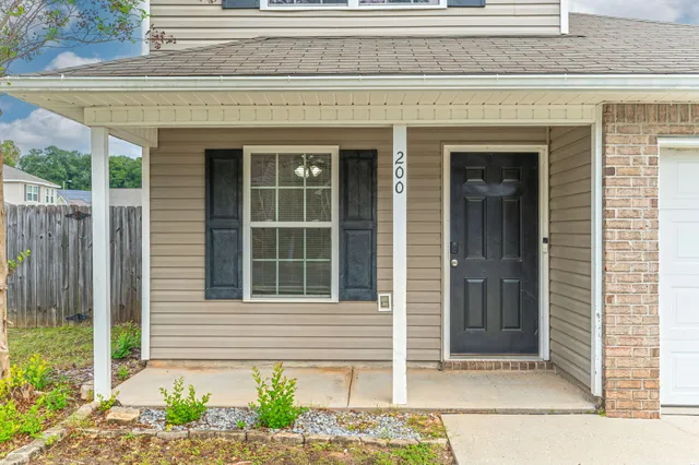 a front view of a house with a window and a chair