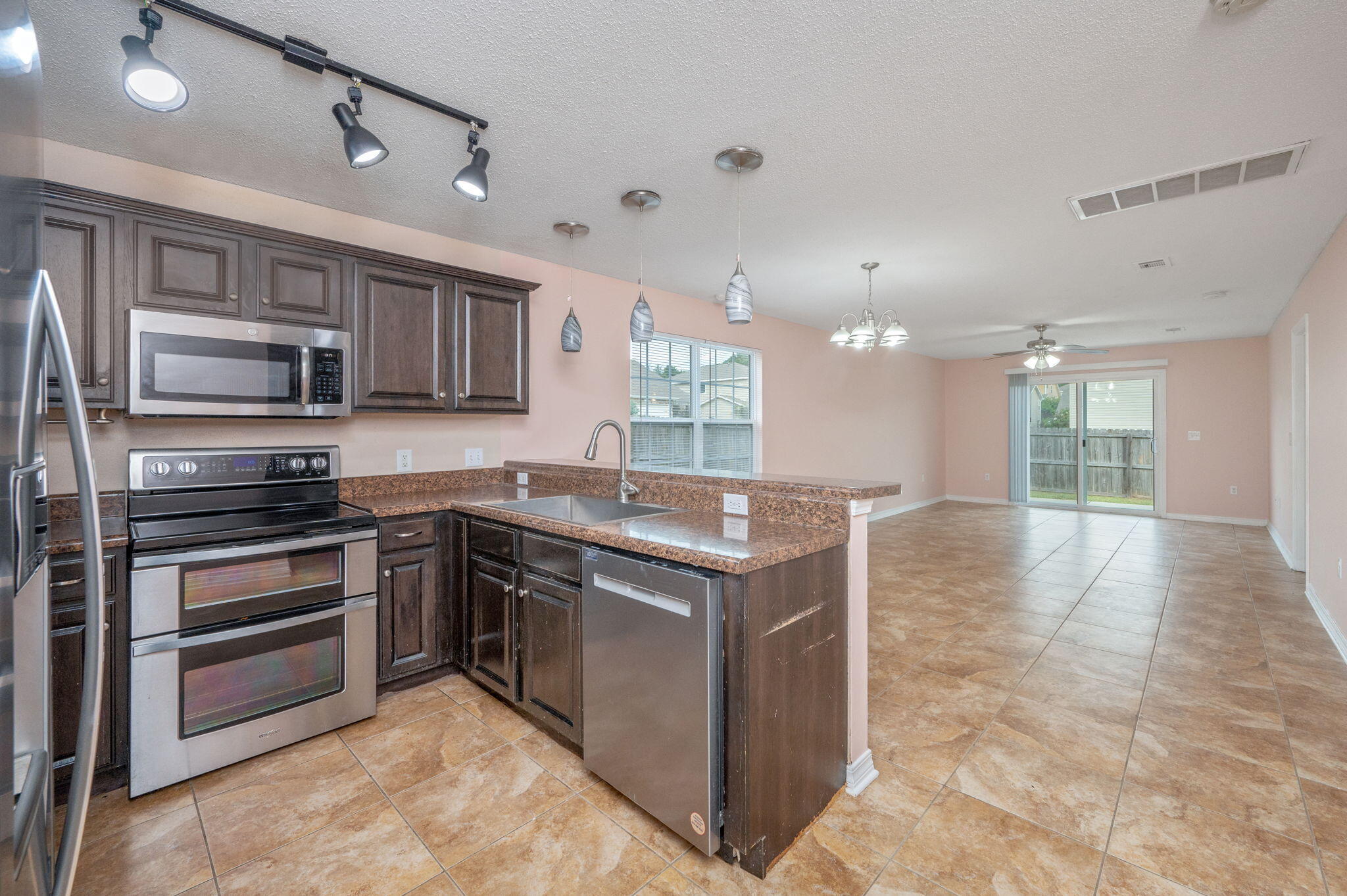 200 Wainwright Drive Crestview, FL 32539 - Photo 6 of 44 a kitchen with stainless steel appliances granite countertop a stove top oven a sink and a refrigerator