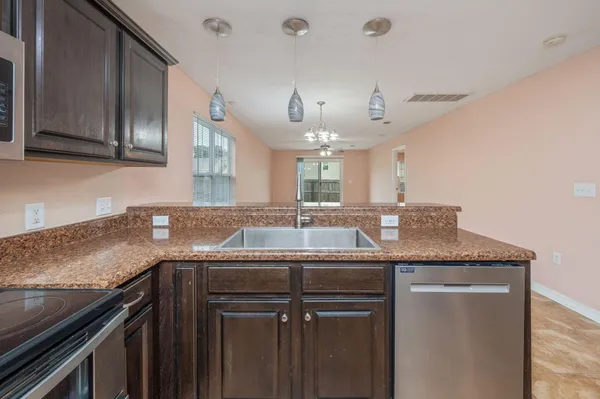a kitchen with granite countertop a sink and cabinets