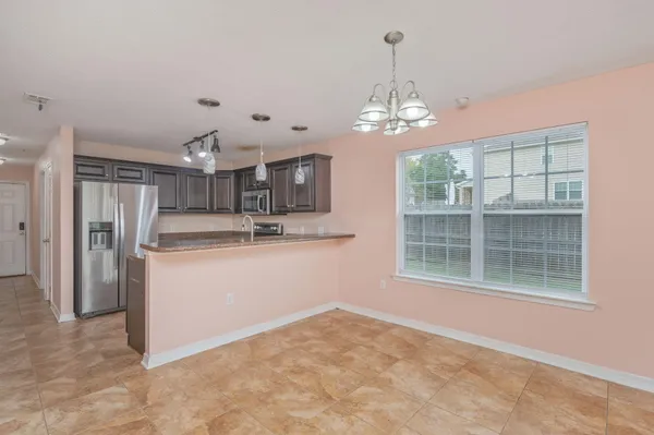 a view of a kitchen with refrigerator and windows