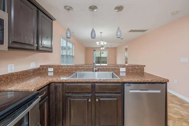 a view of a kitchen with refrigerator and windows