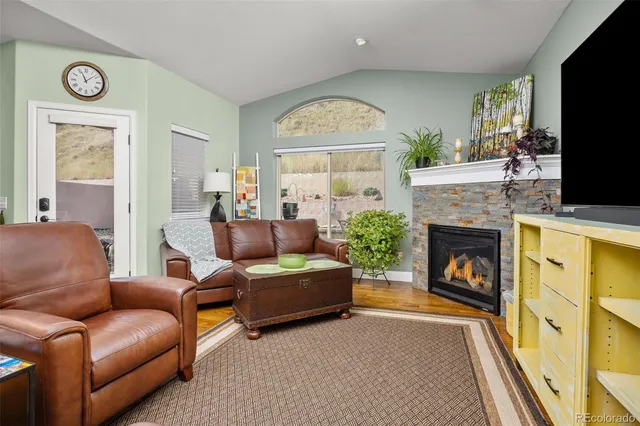 a living room with furniture a fireplace and a flat screen tv