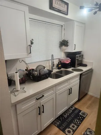 a kitchen with stainless steel appliances a sink dishwasher stove and cabinets