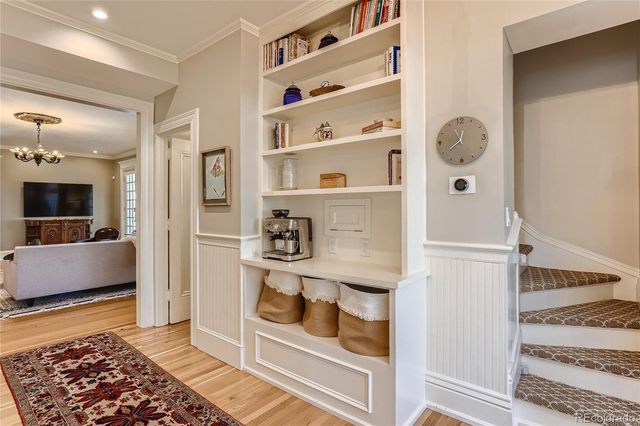 a hallway with white cabinets and chandelier