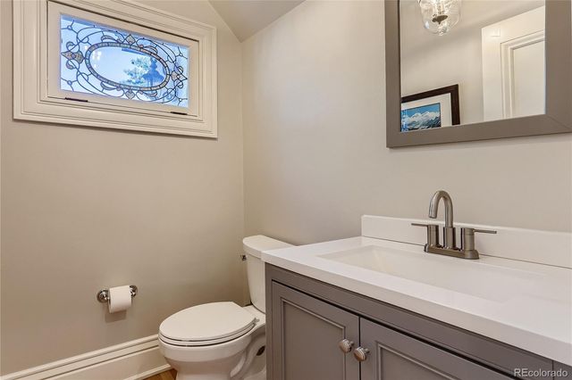 a bathroom with a toilet a sink and mirror