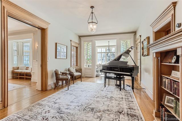 a living room with furniture a piano and a bookshelf