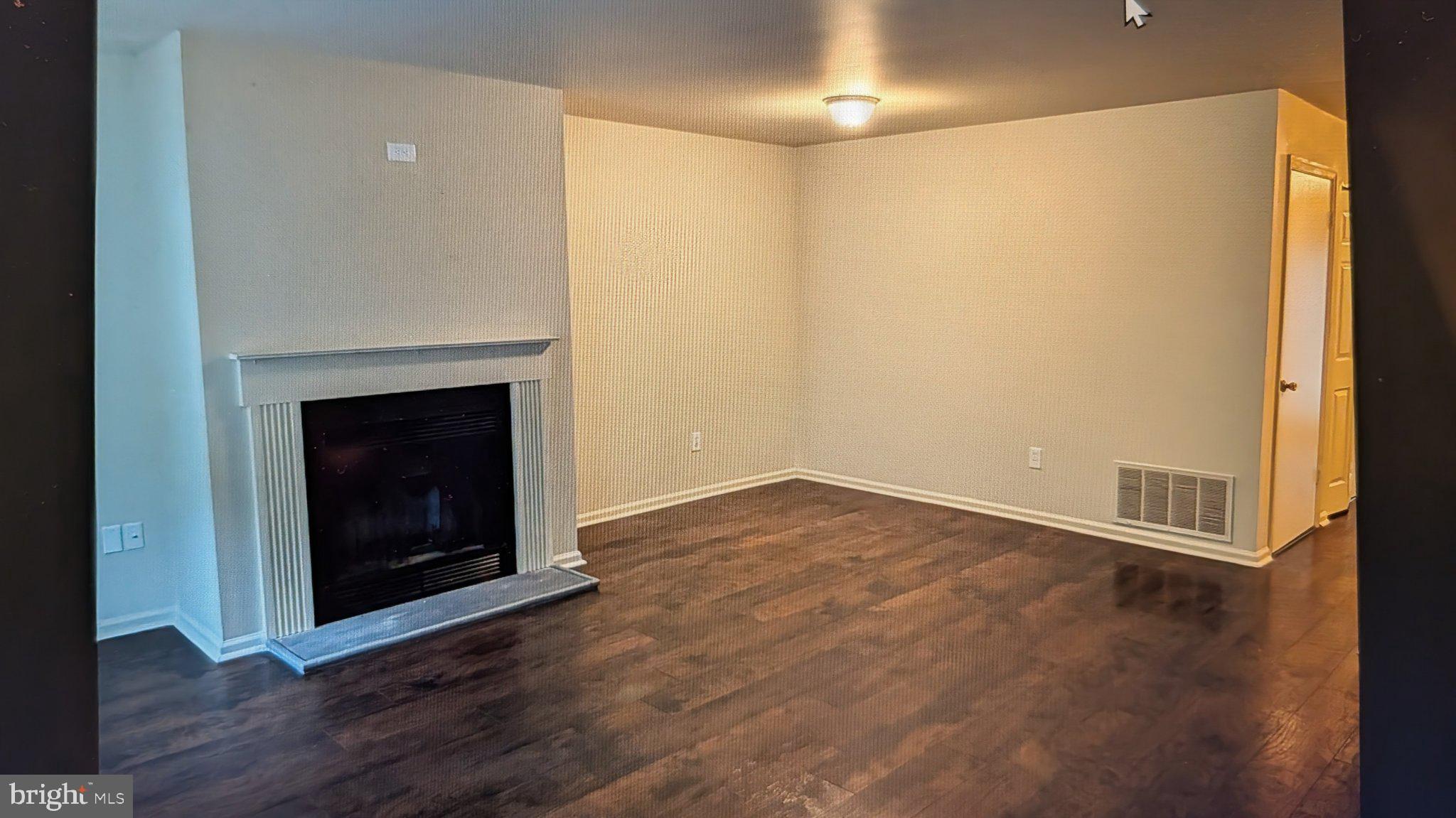 1204 Huntingdon Mews Clementon, NJ 08021 - Photo 2 of 10 an empty room with wooden floor and fireplace
