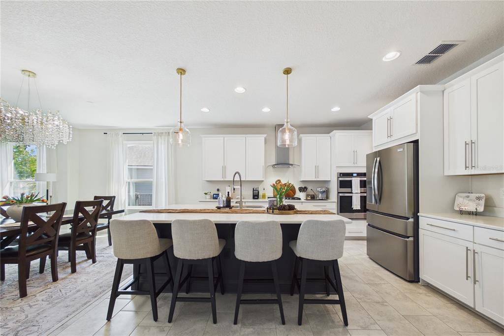 458 Convex Lane St. Augustine, FL 32095 - Photo 11 of 60 a kitchen with stainless steel appliances a dining table chairs stove and refrigerator