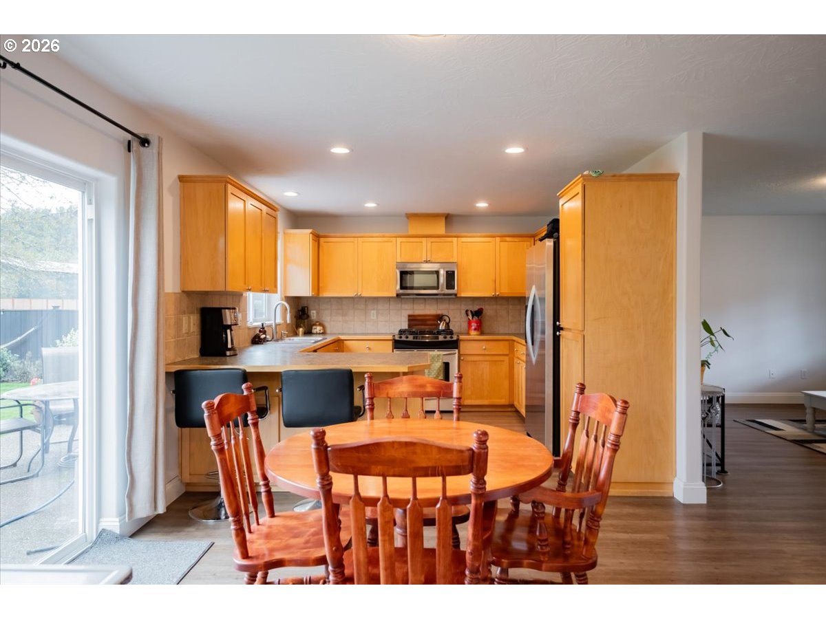 302 Division Street Northeast Silverton, OR 97381 - Photo 13 of 48 a dining room with stainless steel appliances kitchen island granite countertop a dining table and chairs