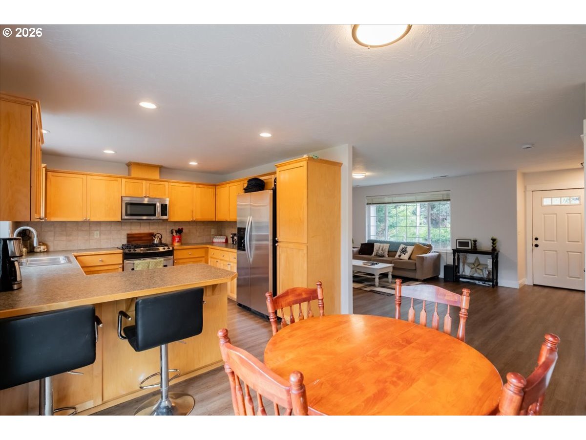 302 Division Street Northeast Silverton, OR 97381 - Photo 14 of 48 a kitchen with stainless steel appliances kitchen island granite countertop a table chairs and a refrigerator