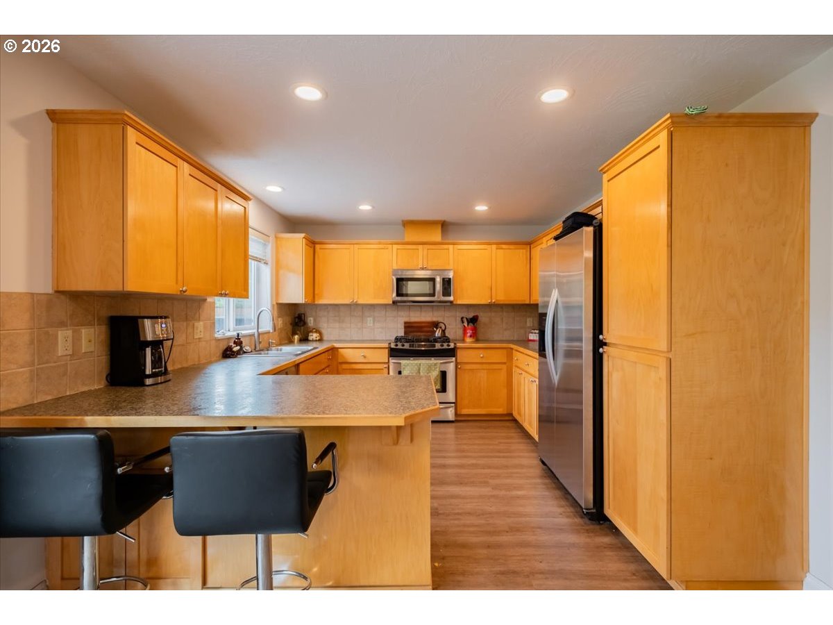 302 Division Street Northeast Silverton, OR 97381 - Photo 15 of 48 a kitchen with stainless steel appliances granite countertop a sink refrigerator and cabinets