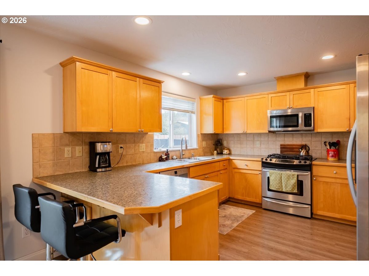 302 Division Street Northeast Silverton, OR 97381 - Photo 16 of 48 a kitchen with stainless steel appliances granite countertop a sink a stove top oven a counter space and cabinets