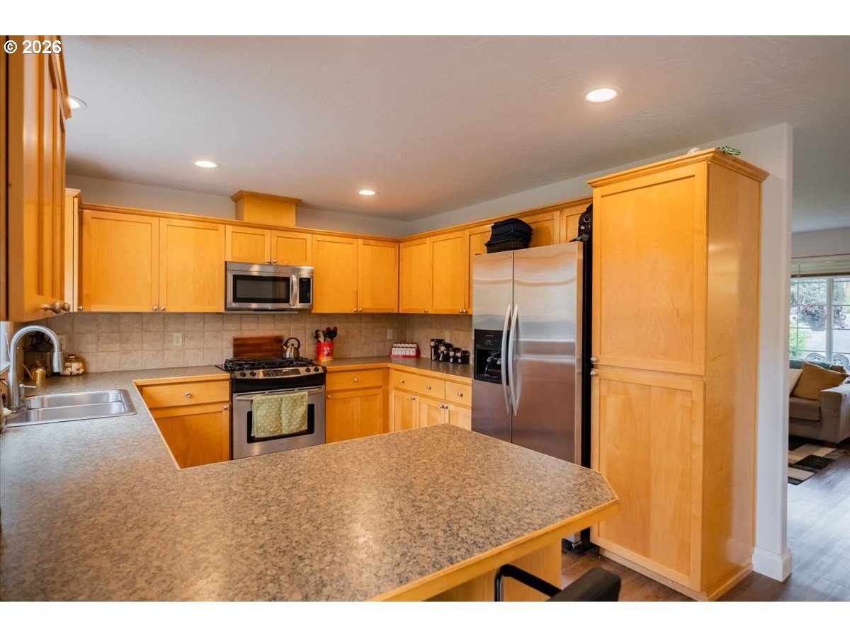302 Division Street Northeast Silverton, OR 97381 - Photo 18 of 48 a kitchen with stainless steel appliances granite countertop a refrigerator a stove top oven a sink and dishwasher