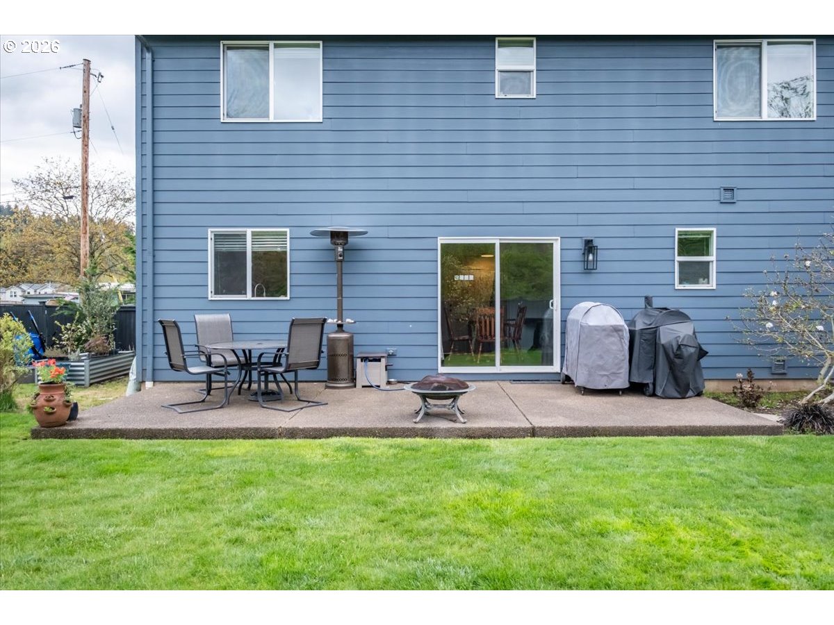 302 Division Street Northeast Silverton, OR 97381 - Photo 39 of 48 a view of a backyard with table and chairs potted plants and a wooden fence