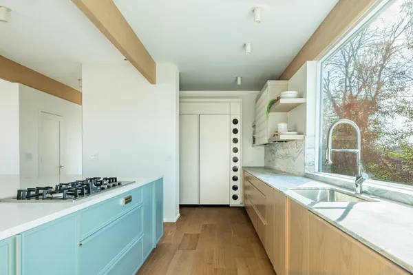 a kitchen with stainless steel appliances granite countertop a sink and a stove next to a window