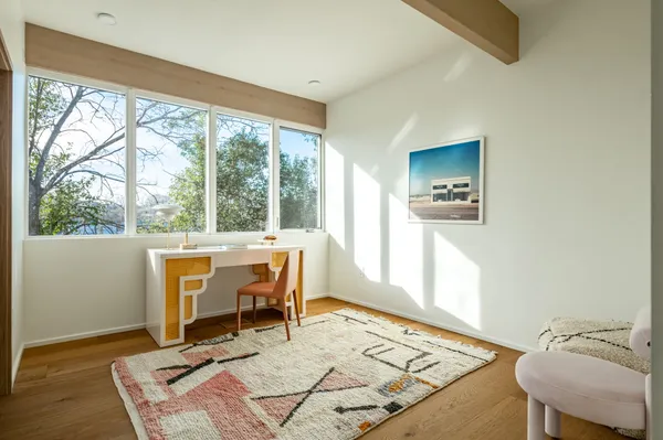 a view of a workspace with furniture and a window