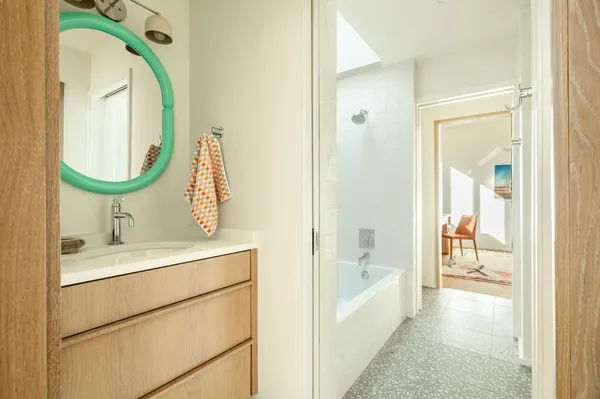 a bathroom with a sink mirror vanity and bathtub