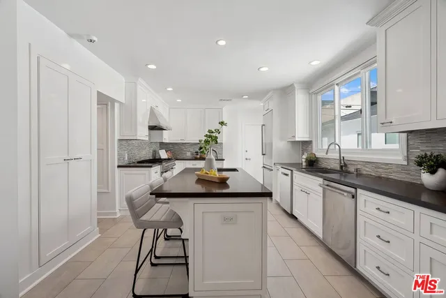 a kitchen with stainless steel appliances granite countertop a sink a stove and a refrigerator